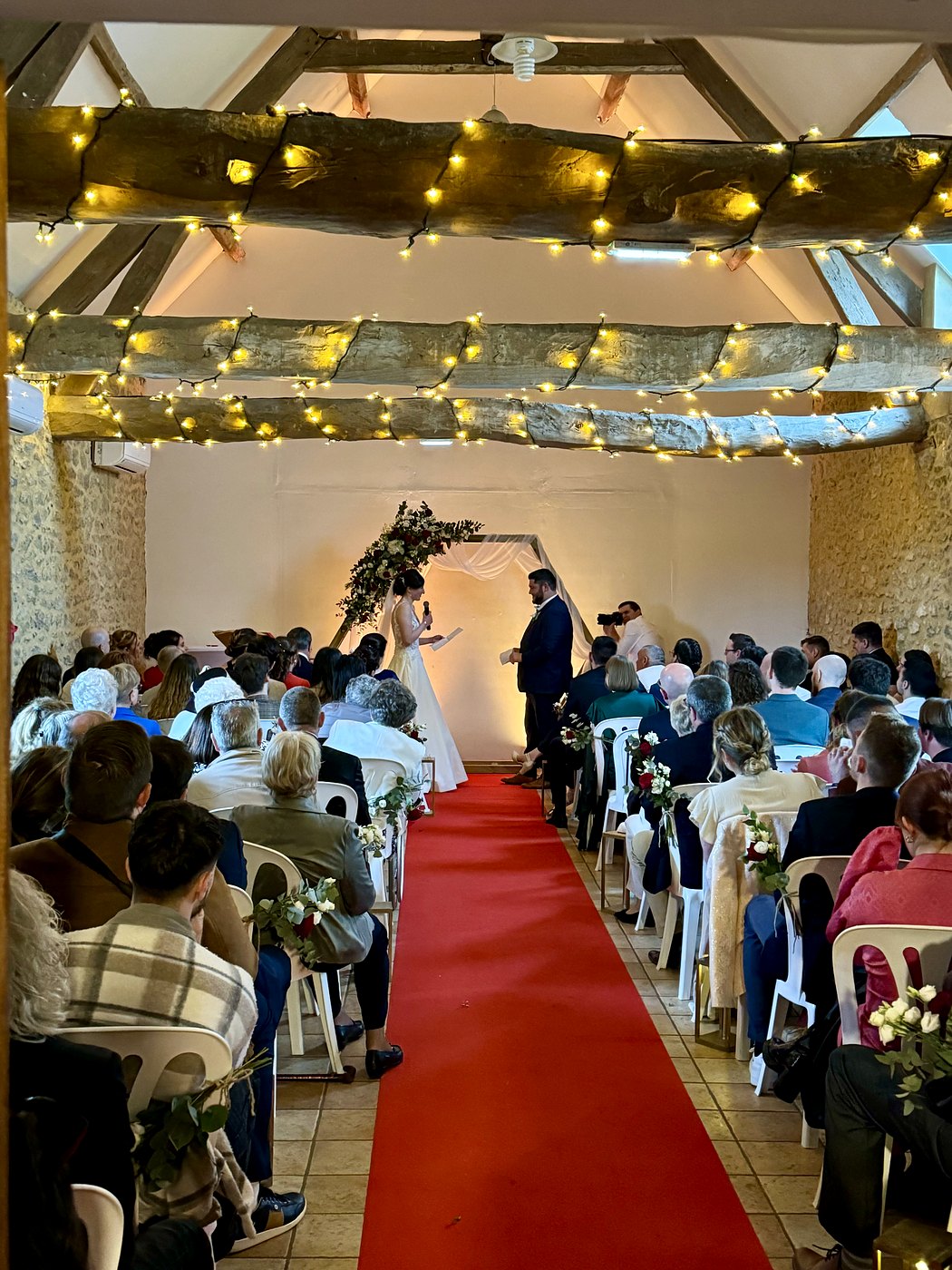 Cérémonie laïque de mariage en intérieur, allée sur tapis rouge et guirlandes lumineuses, Nord