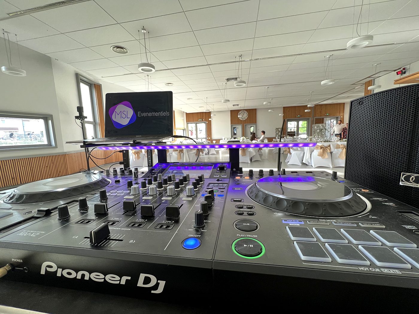 Installation de sonorisation et régie DJ montées dans une salle de réception, avant l'arrivée des invités